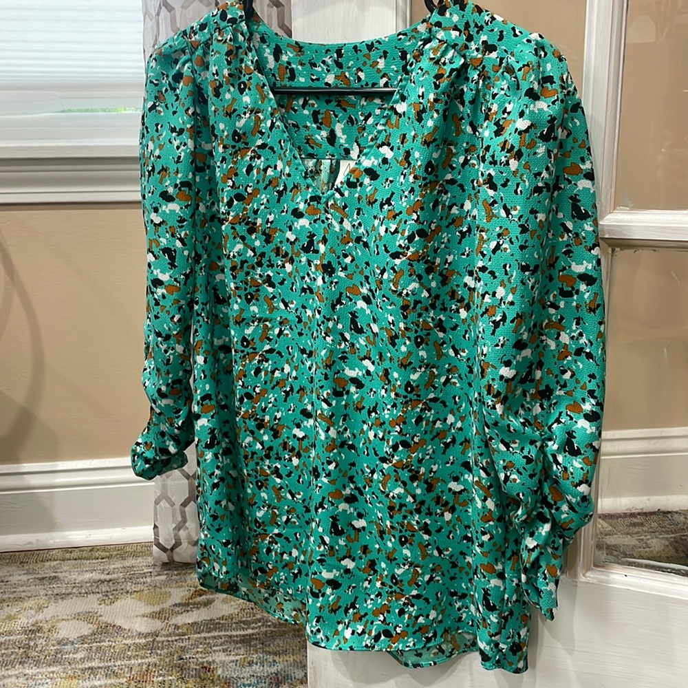 3/4 sleeve, v neck blouse that Is sea green with specs on white, brown and black